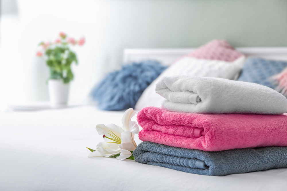 Stack,Of,Clean,Towels,On,Bed