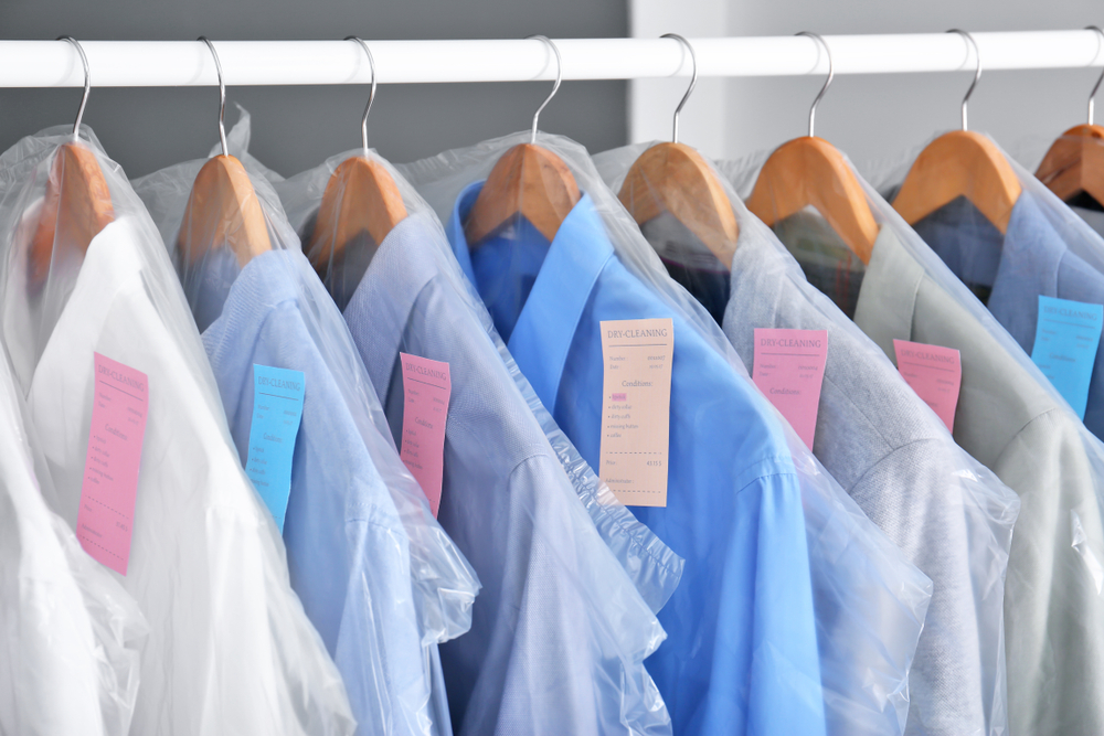 dry cleaned clothes hanging on a rack
