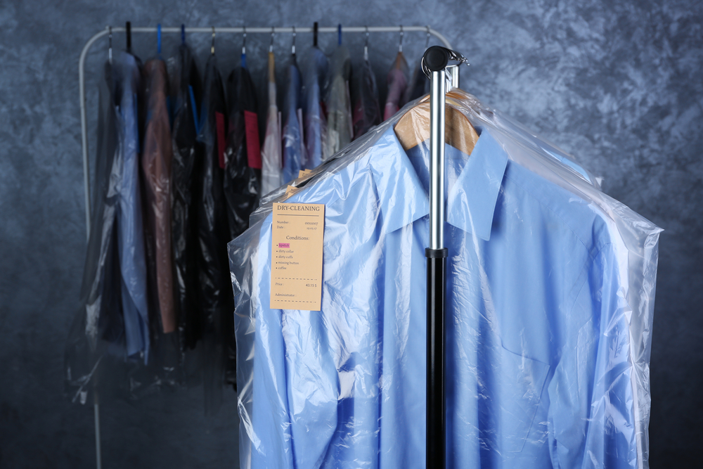 rack of dry cleaned clothes hanging